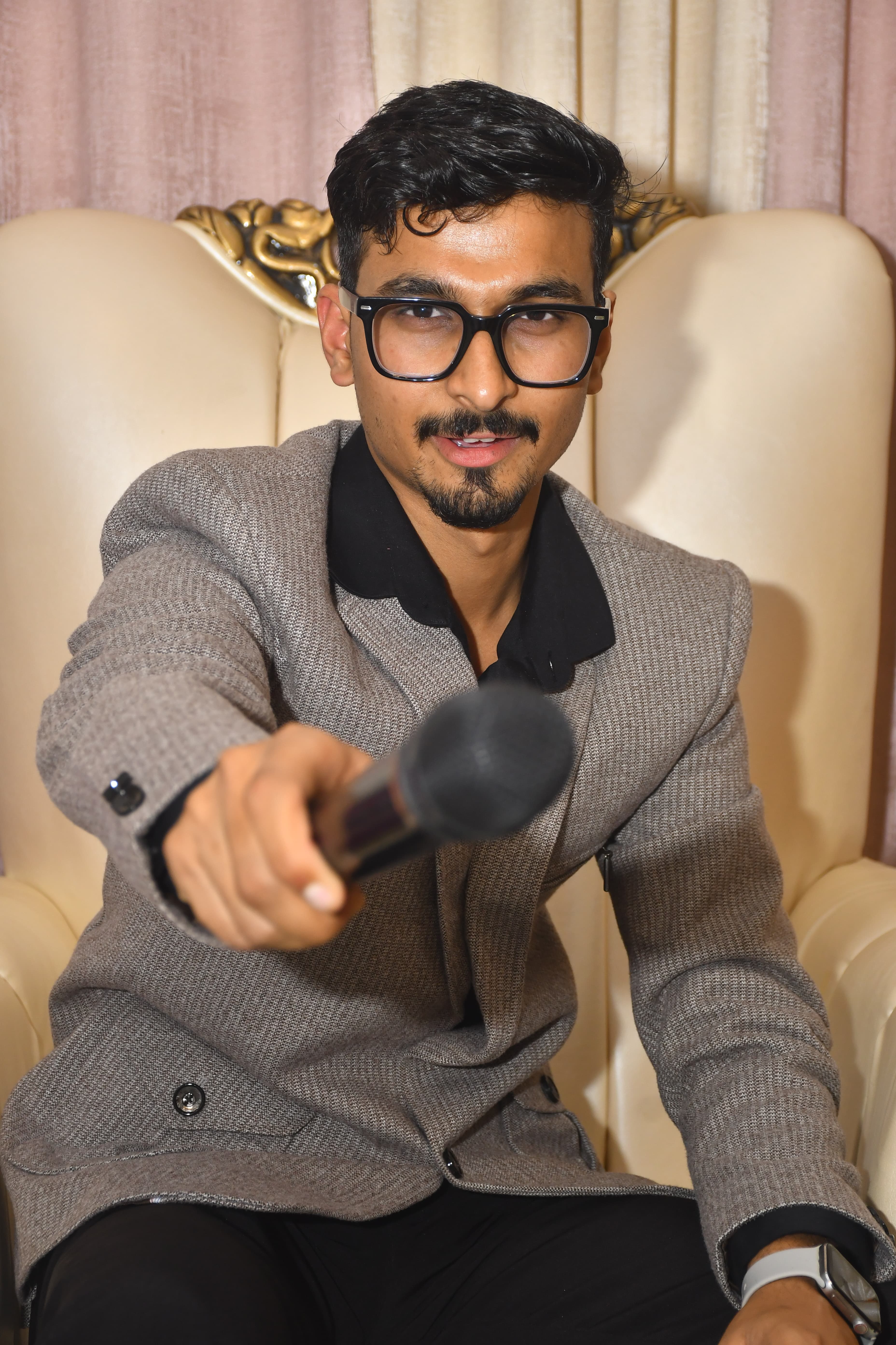 Anchor Nikhil Gupta holding the microphone, engaging the audience